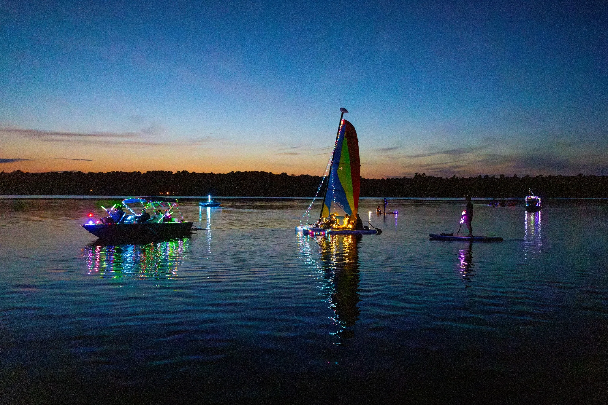 Illuminated sailboats on Lake Naomi at twilight