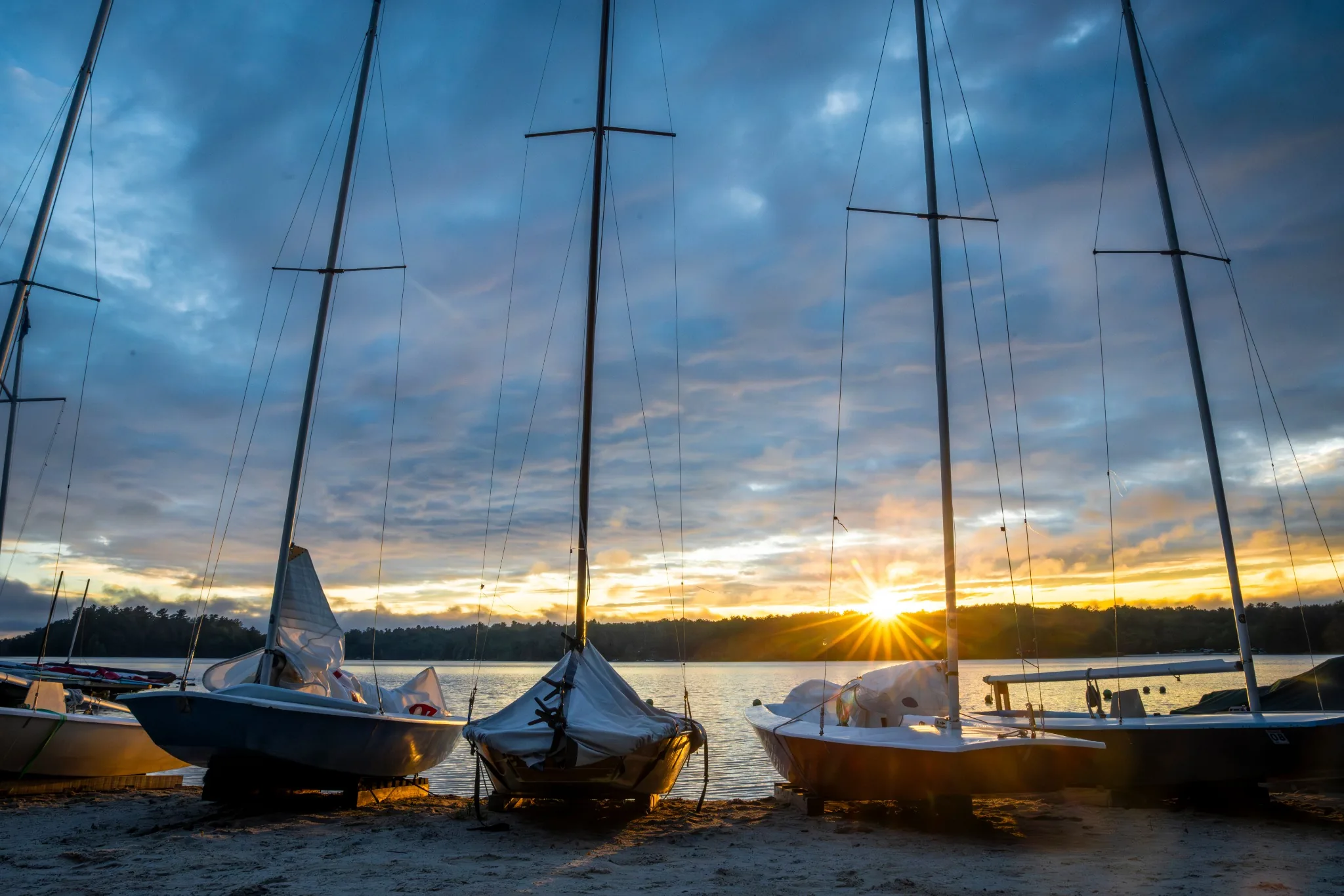 Sailboats silhouetted beneath a dramatic Lake Naomi sunset