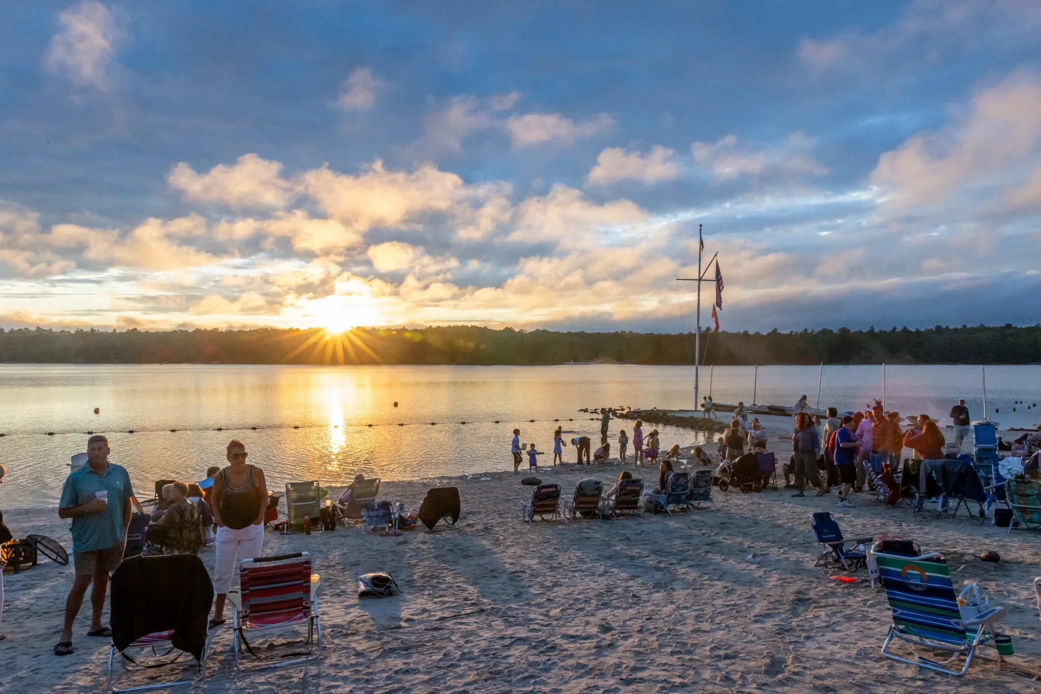 Community gathering on the Lake Naomi beach at sunset