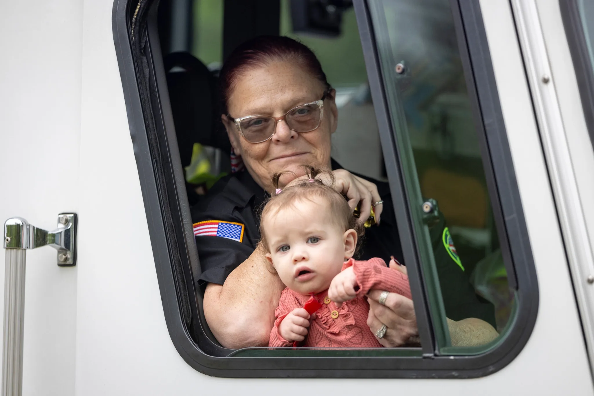 Adult and child framed in a vehicle doorway during the Memorial Day parade